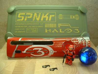 Package included a SPNKR Ammo box that held a custom red Halo 3 plate, a battle-damaged red Spartan Kubrick, and a 