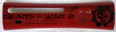 Most of the marketing materials for Gears of War featured a blood red cog on black backgrounds. Early marketing for GoW2 had the colors reversed so that was the direction taken with this plate. The background was sprayed but the lettering and cog were dabbed on to try to reproduce the texture and the glossy look of the early artwork. This plate was signed by Cliff Bleszinski aka 